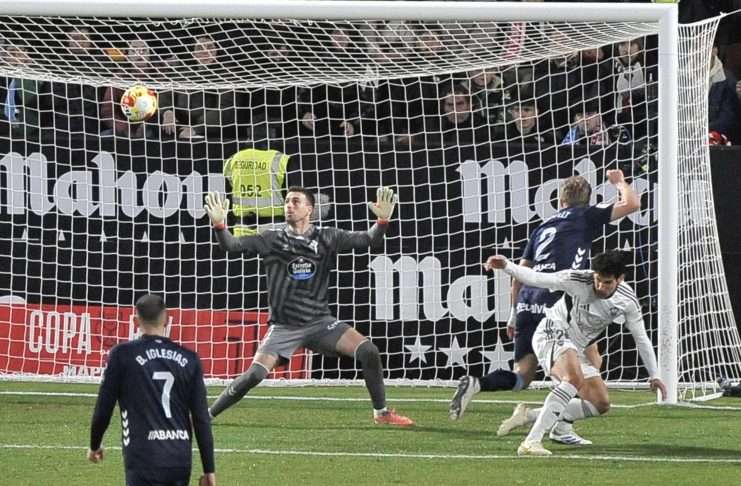 El guardameta del Celta, Iván Villar (i), intenta detener el remate del defensa del Albacete, Jesús Vallejo (d), en la jugada que ha significado el segundo gol del equipo albaceteño durante el encuentro correspondiente a los dieciseisavos de final de la Copa del Rey que disputaron Albacete y Celta en el estadio Carlos Belmonte de Albacete. EFE / Manuel Podio.